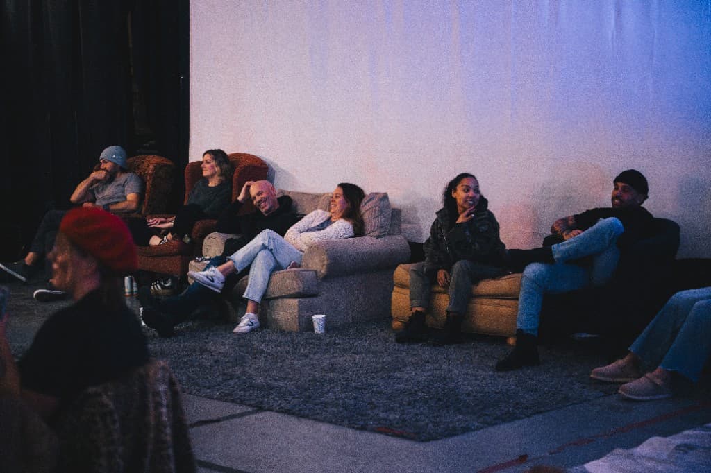 Audience seated on couches watching the show