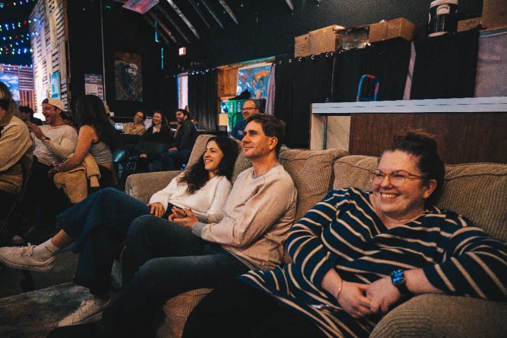 Intimate comedy room audience seated on couches at The Comedy Run Club